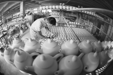 庄家荣在制陶车间检查坯体。